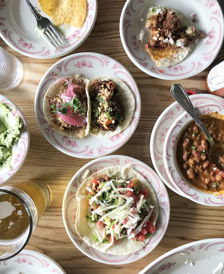 Tacos, frijoles y ensaladas servidos en platos de cerámica