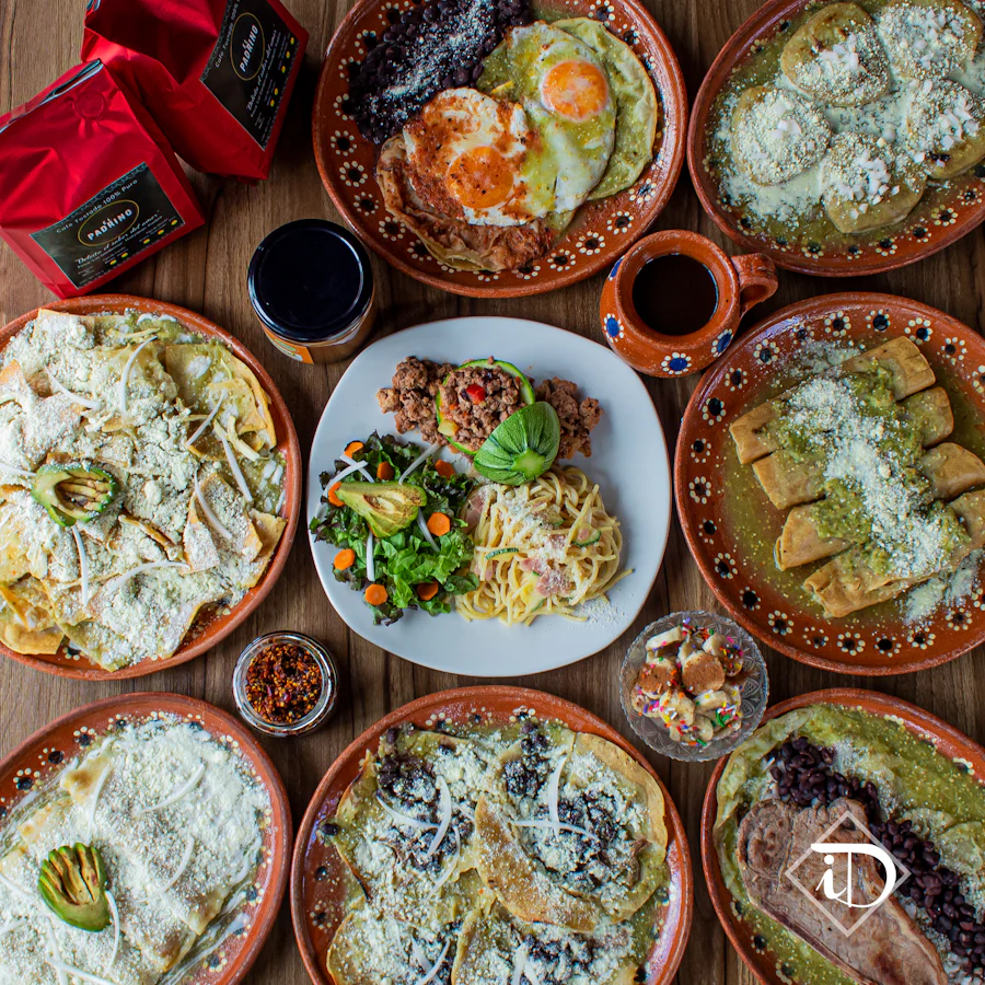 Mesa vista desde arriba con platos de barro, tortillas y salsas